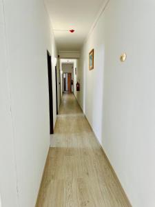 a long hallway with white walls and a wooden floor at Residencial Pimenta ,Portimao,Algarve in Portimão