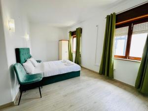 a bedroom with a bed and a green chair at Residencial Pimenta ,Portimao,Algarve in Portimão