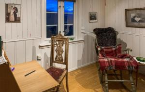Zimmer mit einem Stuhl, einem Tisch und einem Fenster in der Unterkunft 2 Bedroom Awesome Home In Dovre in Dovre