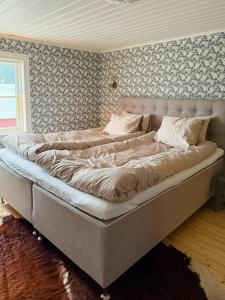 ein großes Bett in einem Schlafzimmer mit einer Wand in der Unterkunft Historic Cottage Near Wiredaholm in Aneby