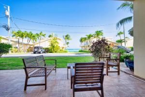 two chairs and a table on a patio with palm trees at Quiet Beach Escape in George Town