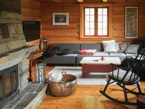 a living room with a couch and a fireplace at Cabin With Wooden Interior By Lake Tinnsjøen in Atra
