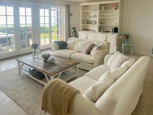 a living room with two white couches and a coffee table at Beachfront Summerhouse With Amazing View And Peace in Hesselager