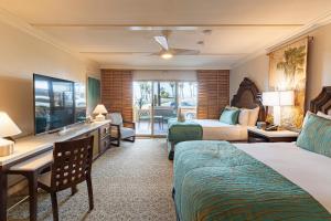 a hotel room with two beds and a television at Pacific Terrace Hotel in San Diego