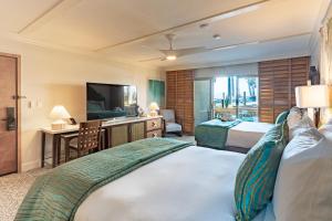 a hotel room with two beds and a television at Pacific Terrace Hotel in San Diego