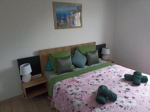 a bedroom with a bed with green and pink sheets at Chambre privée in Montaigu-Vendée