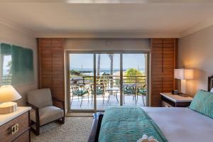 a bedroom with a bed and a balcony with a view at Pacific Terrace Hotel in San Diego