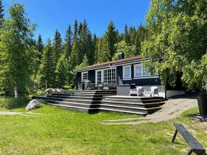 ein Haus mit Stufen, die zu einem Haus führen in der Unterkunft Lakeside Cabin Near Sjusjøen And Lillehammer in Mesnali