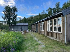 un edificio de madera con ventanas y mesa de picnic en Secluded Mountain Cabin In Rauland With View, en Rauland