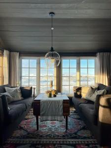 Una sala de estar con dos sofás y una mesa. en Secluded Mountain Cabin In Rauland With View, en Rauland