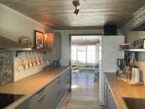 cocina con armarios blancos y suelo de madera en Secluded Mountain Cabin In Rauland With View, en Rauland 31 fotos más