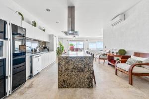 a kitchen with white cabinets and a counter top at Villa Alhelí, Oceanview Escape with Private Pool in Sayulita