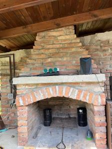 a brick fireplace with a tv on top of it at The Byala Escape, Private Villa with Bar & Hot Tub in Byala
