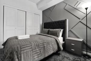 Habitación en blanco y negro con cama y pared en Cozy 2BR Suite Only 8 Mins to The Falls With Sofa Bed And Sleeps 6, en Niagara Falls