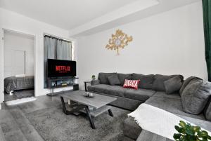 Una sala de estar con un sofá y un televisor. en Cozy 2BR Suite Only 8 Mins to The Falls With Sofa Bed And Sleeps 6, en Niagara Falls