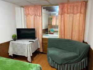 a room with a couch and a table with a tv at Hostel Ruco Machachi in Machachi