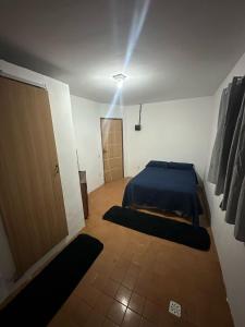 a bedroom with a bed and a door and a light at Suíte no centro in Saquarema +11 photos