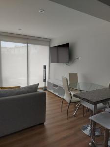 a living room with a couch and a glass table at Lovely & quiet place, park view & private parking in Lima