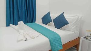 a bed with blue and white pillows on it at Tilano Whitestone Resort in Maria +3 photos