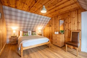 a bedroom with a bed and a chair in a room at Traditional Highland Cottage Near Loch Ness in Drumnadrochit