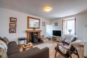 a living room with a couch and a fireplace at Traditional Highland Cottage Near Loch Ness in Drumnadrochit