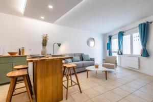 een keuken en woonkamer met een bank en een tafel bij Séjour charmant à L'Écrin du Lez in Castelnau-le-Lez