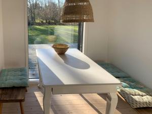 a white table in a room with a window at Charming Cottage Close To Smidstrup Beach in Gilleleje +15 photos