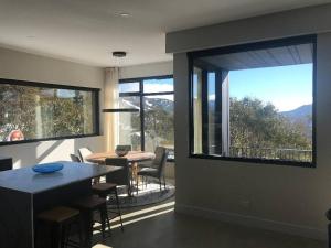 a dining room with a table and a large window at Konayuki Penthouse 9 in Falls Creek