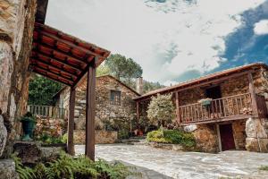 eine Außenansicht eines Steinhauses mit Balkon in der Unterkunft Maria Felícia Village in Castelo de Paiva