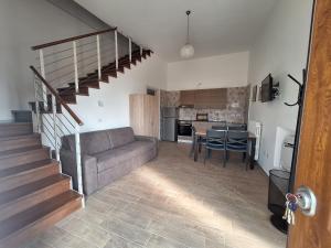 a living room with a couch and a kitchen at Casa Helvius - Dimora in centro storico in Sant'Egidio del Monte Albino +12 photos