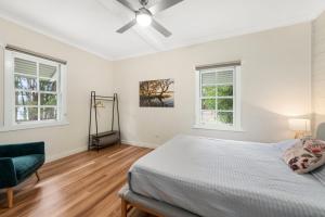 une chambre avec un lit et deux fenêtres dans l'établissement Cutlers Cottage, à Bombah Point