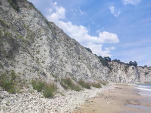 a rocky hillside next to a beach with the ocean at The Byala Escape, Private Villa with Bar & Hot Tub in Byala