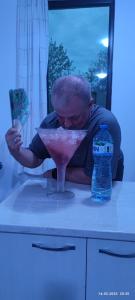 a man bending over a table with a martini glass at The Byala Escape, Private Villa with Bar & Hot Tub in Byala