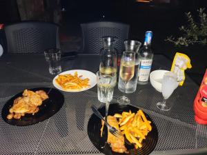 a table with two plates of food and glasses of wine at The Byala Escape, Private Villa with Bar & Hot Tub in Byala