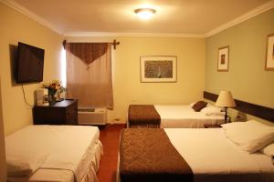 a hotel room with two beds and a television at Hotel Los Altos Esteli in Estelí