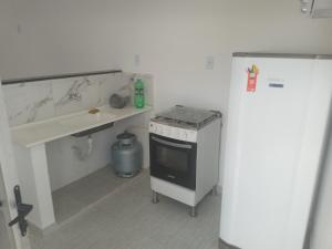 a kitchen with a counter and a sink and a stove at Vila Bárbara superior in Araruama