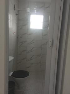 a bathroom with a toilet and a window at Vila Bárbara superior in Araruama +11 photos