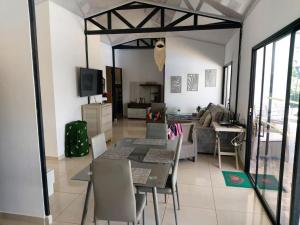 a dining room and living room with a table and chairs at Finca Doña Ime in Calimita