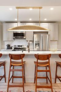 a kitchen with white cabinets and a island with bar stools at Luxury King Suite Full Kitchen 3rd Floor in Savannah +24 photos