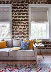 a living room with a couch and a brick wall at Luxury King Suite Full Kitchen 3rd Floor in Savannah