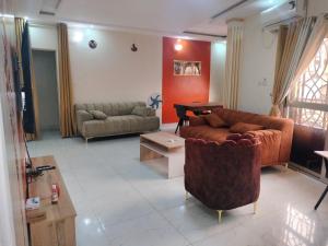 ein Wohnzimmer mit einer Couch und einem Tisch in der Unterkunft Résidence Diakhaby in Conakry