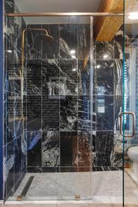 a shower with a glass door in a bathroom at King Suite 4th Floor Downtown Hotel Boutique in Savannah