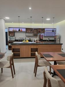 a large kitchen with wooden cabinets and tables at Pousada Big Bear II in Campos do Jordão