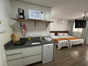 - une cuisine équipée d'un four micro-ondes et un lit dans une chambre dans l'établissement SeuLar o conforto de um Lar em Qualquer Lugar, à São Paulo
