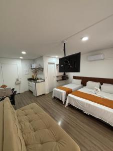 une chambre d'hôtel avec deux lits et un canapé dans l'établissement SeuLar o conforto de um Lar em Qualquer Lugar, à São Paulo