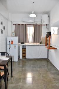 a kitchen with a counter and a refrigerator and a table at Departamento en Planta baja, centrico, Practico, Estacionamiento D2 in San Fernando del Valle de Catamarca +20 photos