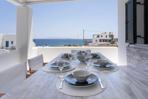 a table with plates and wine glasses on a balcony at White Wave in Logaras