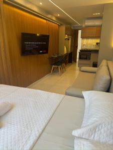 a hotel room with a bed and a tv on a wall at EcoMirage - Flats Premium - Porto de Galinhas in Porto De Galinhas