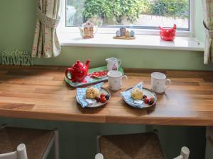 ein Tisch mit zwei Tellern mit Essen und Teekannen in der Unterkunft The Miners Cottage in Loftus + 17 Fotos