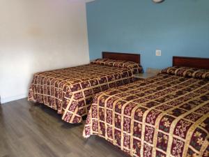 two beds in a room with blue walls at Value Inn in Sylmar